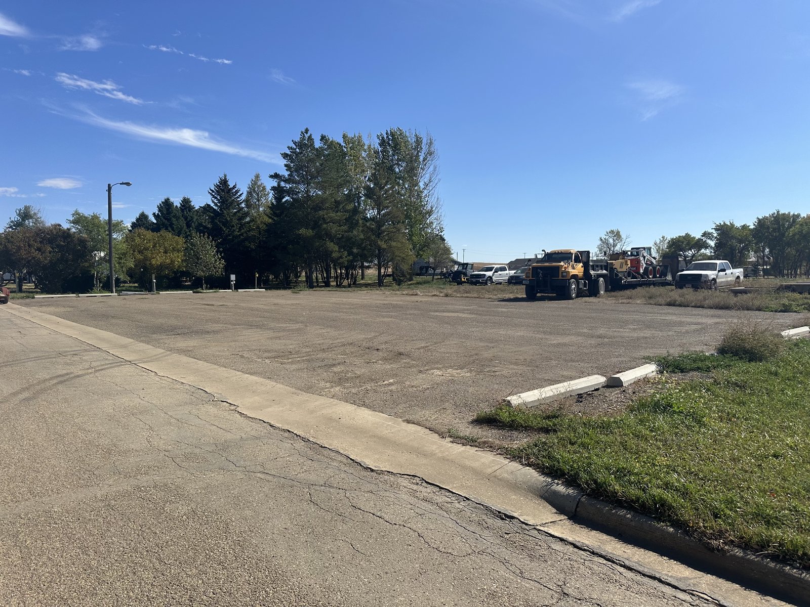 Commercial parking lot before paving — cracked and weedy
